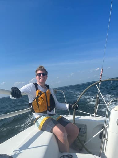 Alex Quintana, founder of Cogit sailing crew management app, at the helm on Long Island Sound